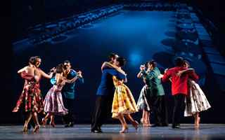 Ten people are dancing the tango on stage.
