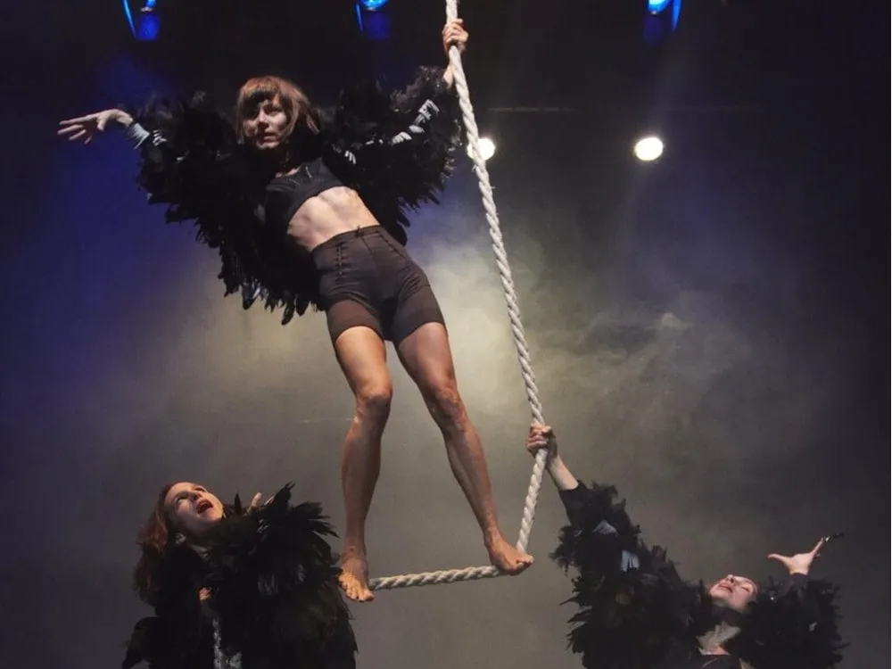 Photo of the performance 'Raven' by Still Hungry. Two women hold a rope which another woman stands on.