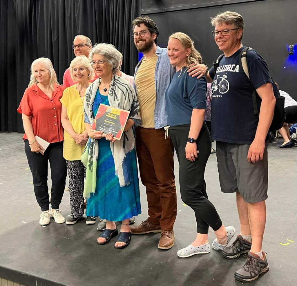 Photo of six people standing in a studio. 