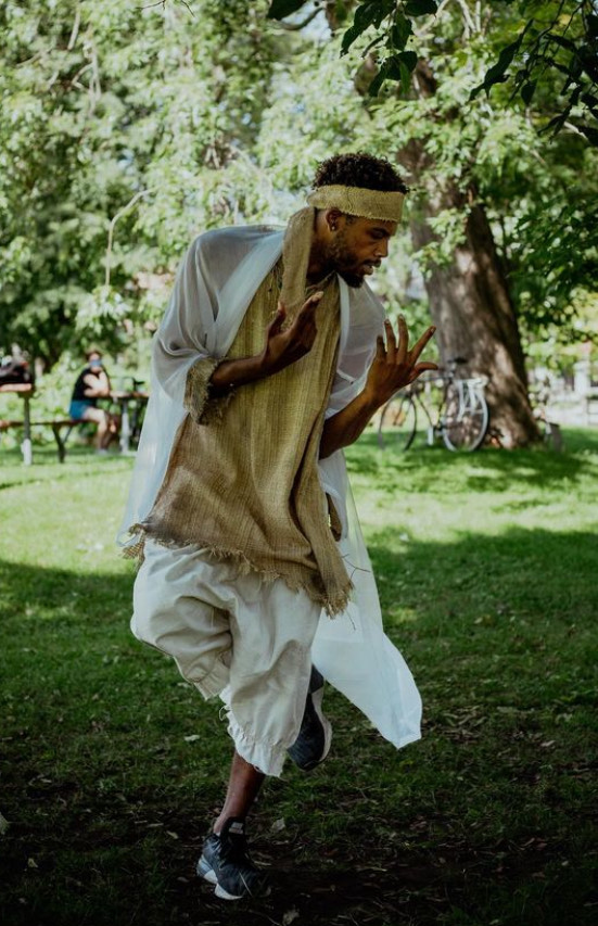 A man dancing in a park. 