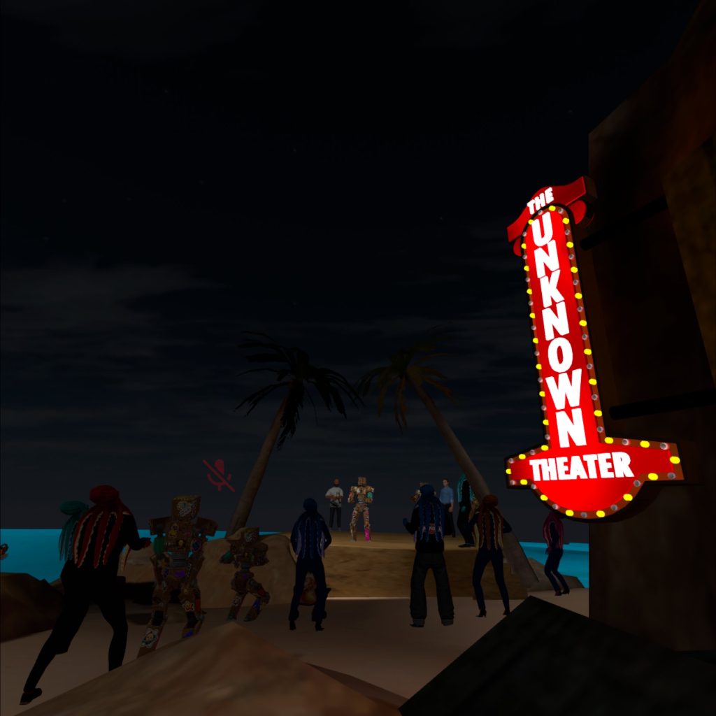 Image of a performance in VR. The setting is entirely virtual. There is a body of water in the background with avatars standing on a sandy area. There is a very bright sign that says "The Unknown Theater". 