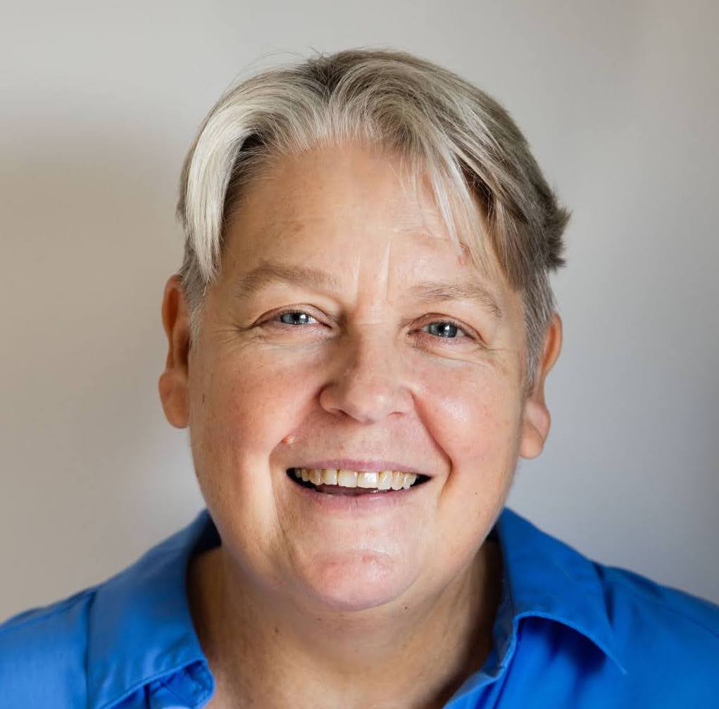 Headshot of Kate Barker. She smiles at the camera.