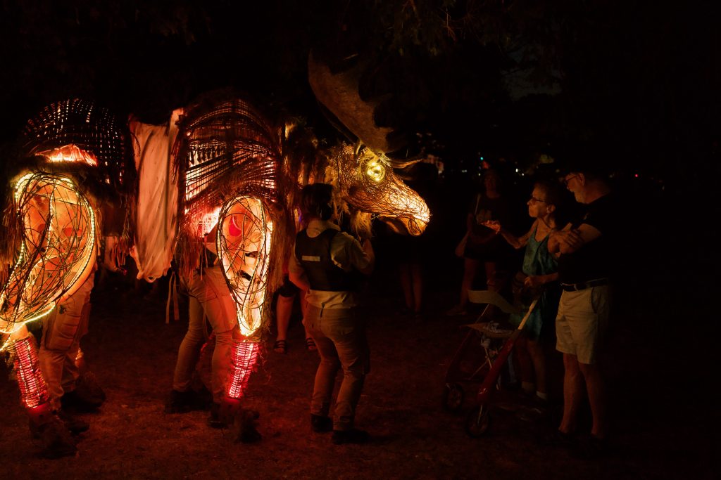 Large puppet moose approaching audience members. 