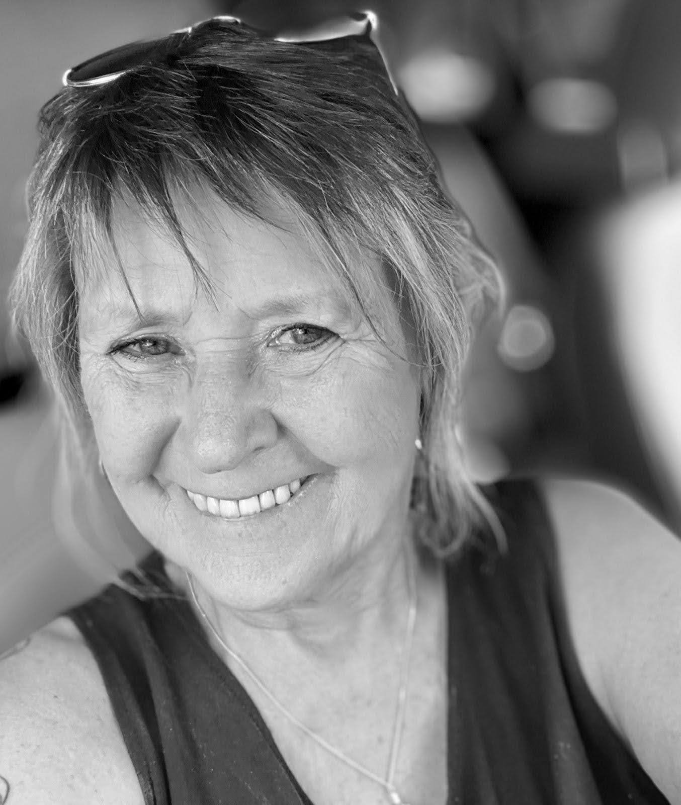 Black and white headshot of Janet Kish. She smiles at the camera.