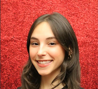 Headshot of Julia Gehring. She smiles in front of a red background.