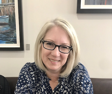 Headshot of a woman with blonde hair. She smiles.