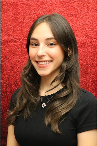 Headshot of Julia Gehring. She smiles in front of a red background.