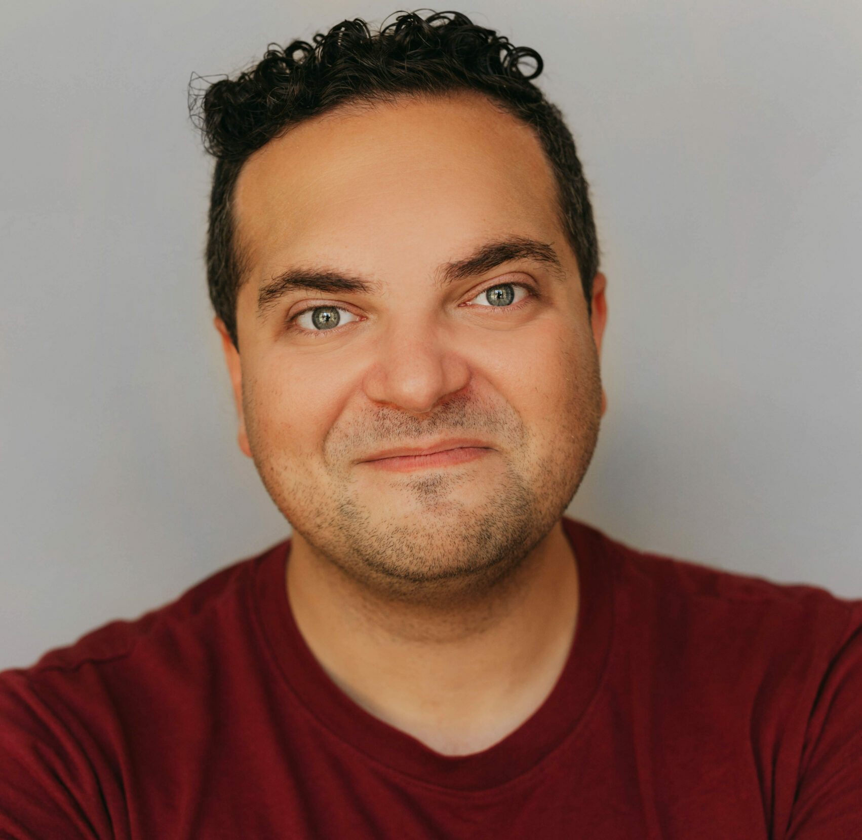A man in a read shirt with dark hair.