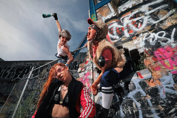 Three people in rave clothing screaming